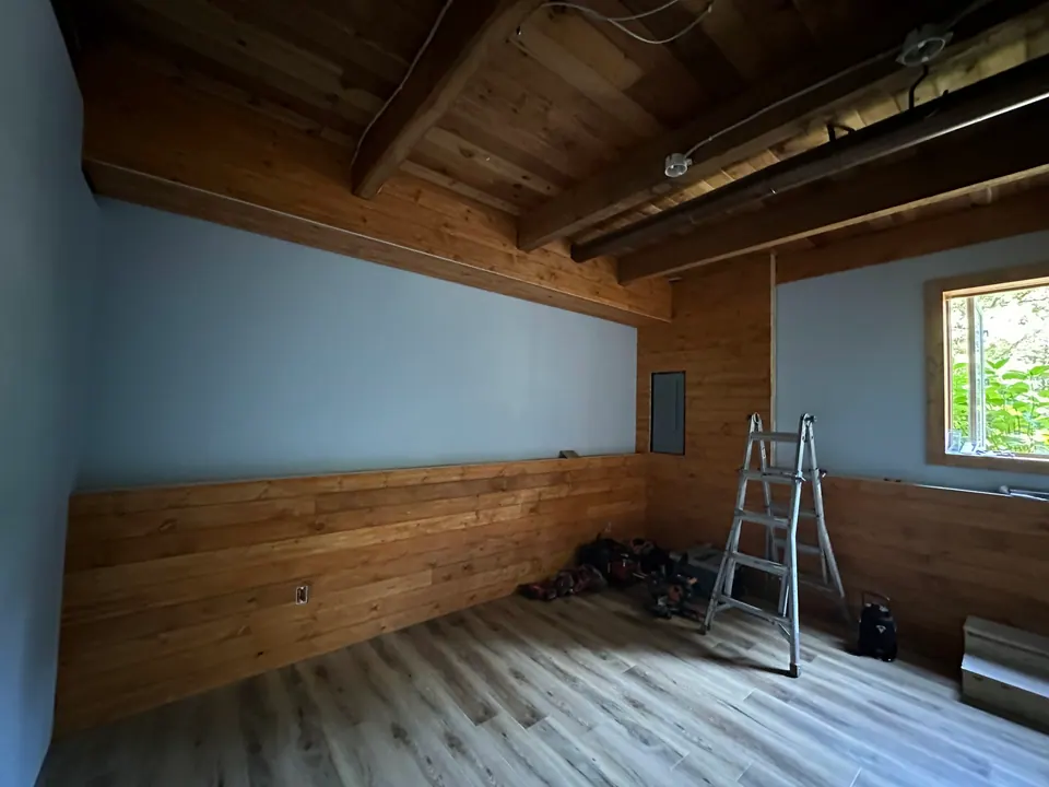 Interior room remodel with new wood paneling and drywall in progress
